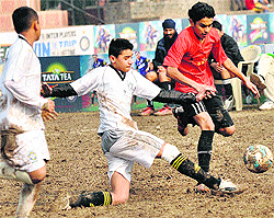 Players struggle for the ball during a football match at Sector 17, Chandigarh, on Tuesday