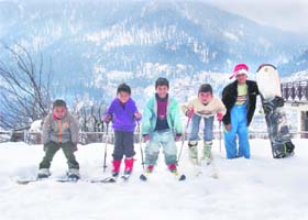 After snowfall, boys enjoy skiing near Manali on Tuesday