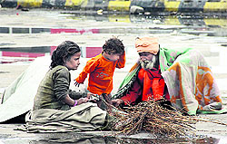 A homeless family with a child sitting in the open in Jalandhar on Tuesday