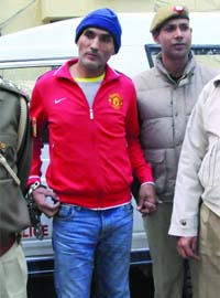 The Delhi police produces Devinder Singh, aka Bunty Chor, before the media on Wednesday at the New Friends Colony police station in New Delhi after his arrest from Bhopal last week