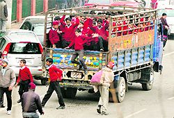 School children stuffed like sardines in a mini-truck jump from vehicles to take part in the 57th National School Games at Guru Nanak Stadium in Ludhiana on Wednesday