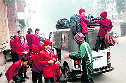 Schoolchildren alight from an overloaded autorickshaw at a private school in Rohtak on Thursday