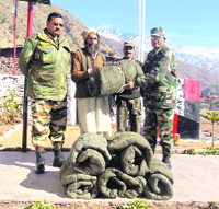 An Army officer hands over a blanket to a snow-hit resident.