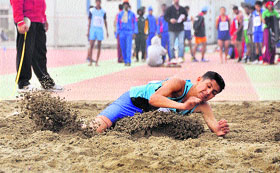 An athlete attempts triple jump.