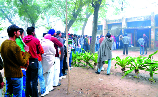 People stand in queue despite biting cold at the Punjab School Education Board (PSEB) book depot in Civil Station area. 