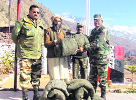 An Army officer hands over a blanket to a snow-hit resident.