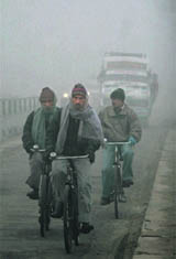 People on their way on a foggy day at RS Pura in Jammu.