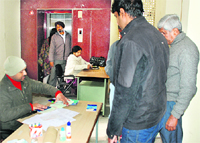 Dr Amita Madan and her assistant sit in front of elevators outside the mini-secretariat at Panchkula on Friday. 