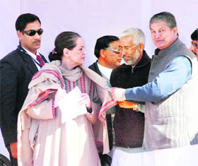 Union Minister of State for Agriculture, Food Processing and Parliamentary Affairs Harish Rawat felicitates Congress president Sonia Gandhi with a shawl at an election rally at Almora on Saturday. 
