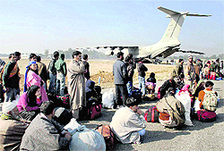 Stranded passengers await their turn to board an Indian Air Force aircraft at the Jammu Airport on Saturday. The IAF operated free air service for stranded passengers, as traffic on the 300-km Jammu-Srinagar national highway remained affected due to heavy snow