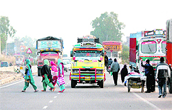 Women cross the Kunjwani-Narwal highway in the absence of a zebra crossing in Jammu