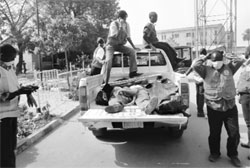 Rescuers carry away bodies of victims killed by multiple blasts and armed assailants in Kano