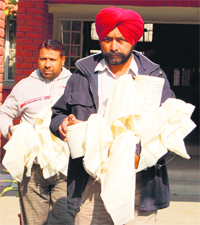 Police personnel with the contraband seized in Amritsar on Sunday.