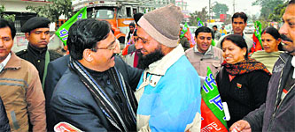 Former Chief Minister Ramesh Pokhriyal Nishank hugs a voter during campaigning in the Doiwala segment on Sunday.