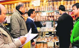 Officials of the UT excise and taxation department and health department inspect eatables during a raid at Nik Bakers, Sector 9, Chandigarh, on Monday