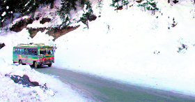 A private bus moves slowly on a snow-covered road at Kufri near Shimla on Monday.
