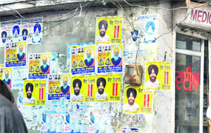 Posters of Independent candidate Simarjit Singh Bains and SAD candidate Hira Singh Gabria pasted on a wall in Ludhiana