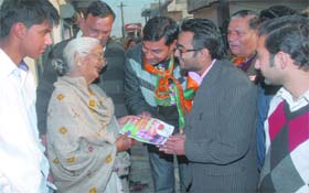Grandsons of Bhagat Chunni Lal, BJP candidate from Jalandhar (West), Atul and Chandan, distribute handouts as they canvass door-to-door at Model House in Jalandhar on Tuesday