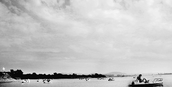 People enjoy boating under the cloudy sky at the Sukhna Lake in Chandigarh
