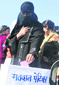 A student dressed as a Muslim girl casts her vote on a tableau as part of a voting awareness drive  in Haridwa