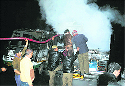 Firefighters battle the flames after two buses caught fire at the Dharamsala bus stand on Tuesday night