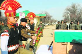 A BSF officer lays a wreath on the coffin of Narender Kumar, who died in an avalanche, in Srinagar on Wednesday