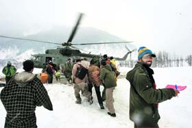 Trapped civilians hurry towards a waiting MI-17 helicopter after the Indian Air Force launched a rescue operation to airlift stranded people in Kishtwar district of Jammu and Kashmir on Wednesday