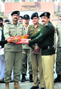 DIG, BSF, Sanjiv Bhanot offers sweets to Wing Commander of Pakistan Rangers, Sohal Khan, (left) on Indias 63rd Republic Day at the Attari-Wagah border in Amritsar