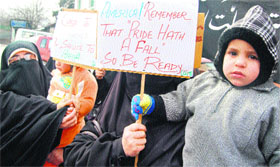 Activists of the Dukhtaran-e-Milat (Daughters of the Faith) along with their children stage a protest holding placards against the detention and sexual harrasment of a Pakistani woman Afia Sidiq in the United States, in Srinagar on Friday