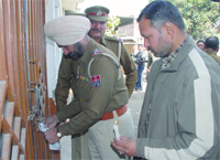 Police officials seal the godown from where cartons of liquor were seized in Jalandhar.