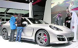 Visitors look at a Porsche Panamera GTS at the at the second international edition of the Qatar International Motor Show in Doha, which ends on Saturday