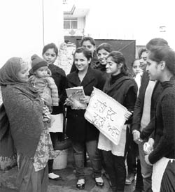 Students educate a resident at Tangori village on elections.