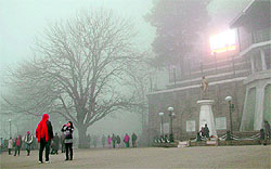 People walk in dense fog in Shimla on Saturday