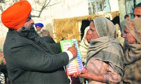 SAD candidate Ch Mohan Lal shows a dummy EVM to village women at Sotran village near Banga on Friday