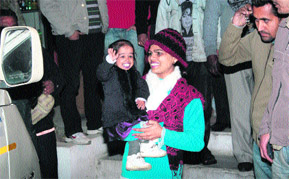 Jyoti Amge (18) of Nagpur, the worlds shortest woman in her elder sisters arms, waves during her visit to Jammu on Saturday.