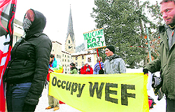 Protesters display a banner and a poster during a demonstration on Saturday against the World Economic Forum (WEF) in the Swiss mountain resort of Davos. From igloos to topless protesters, the World Economic Forum this year had its fair share of innovative protests and campaigns reflecting people's growing frustration with the present economic system and rising inequalities. The annual meet concluded on Sunday