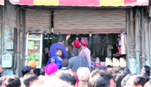 Officials put down shutters of a grocery store near Gill Chowk in Ludhiana on Sunday. 