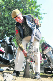 A policeman cleans his rifle in Ludhiana on Sunday.