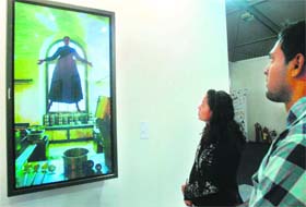 A visitors appreciates a painting at the India Art Fair