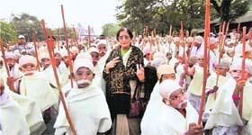 Granddaughter of Mahatma Gandhi Usha H Gokani stands with some of the 485 underprivileged children dressed as Mahatma Gandhi in a walk for peace and a successful attempt to enter Guinness Book of Records in Kolkata on Sunday
