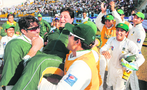Pakistan players carry coach Mohsin Khan (C) after they won the second Test against England.  AFP