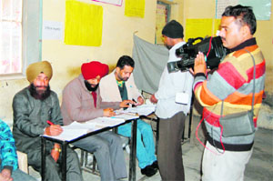 A cameraman makes a video recording of the polling process at a booth during the Assembly elections in Amritsar on Monday. 