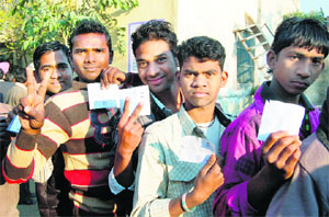 First time voters stand in queue to vote for the future government in Amritsar on Monday. 