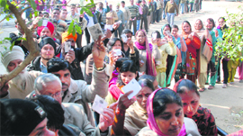 Voters queue up outside a polling booth at the government school in Dera Bassi on Monday.