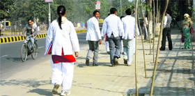 Students of Post Graduate Institute of Medical Sciences, Rohtak, walk down a road near the campus.