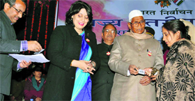 Haryana Governor Jagannath Pahadia hands over a voter card at SD College in Ambala Cantt.