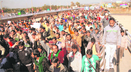 Members of the Jammu and Kashmir PDD Daily Wagers Union protest in support of their demands at the Tawi Bridge in Jammu on Monday. 