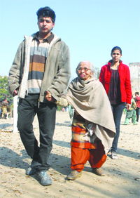 A youth escorts his grandmother to a polling booth.