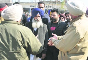 Independent candidate Balwinder Bains stands along with his supporters at a polling station in Lohara on Monday.Tribune photo: Himanshu Mahajan