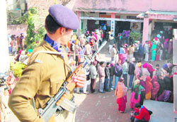 A security personnel outside a booth in Amritsar on Monday.